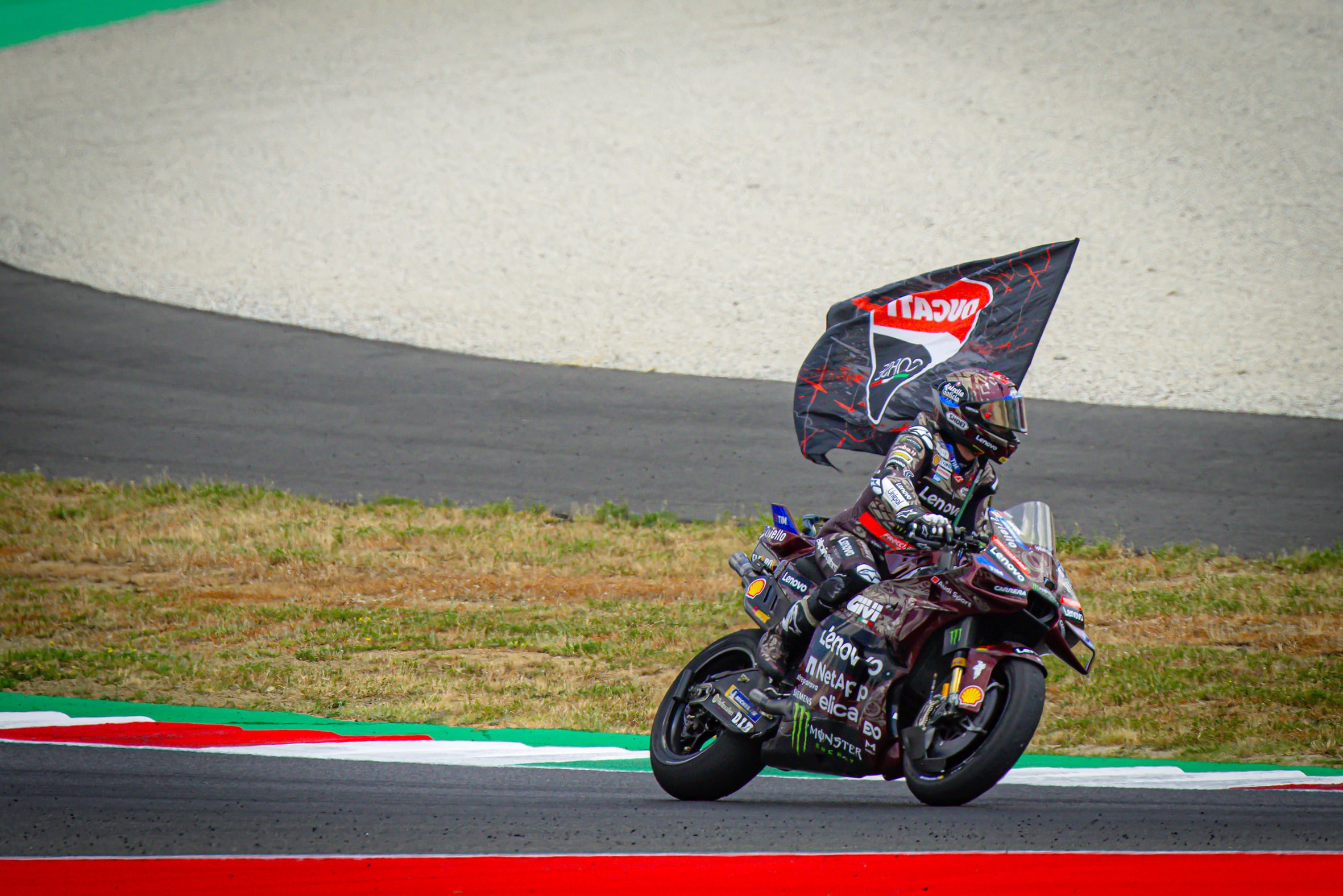 Marc Marquez con la bandiera Ducati (© Ducati)