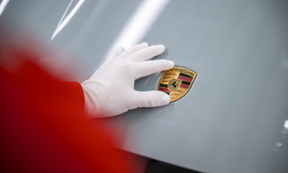 Il marchio Porsche applicato sul cofano di una Taycan elettrica