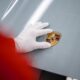 Il marchio Porsche applicato sul cofano di una Taycan elettrica