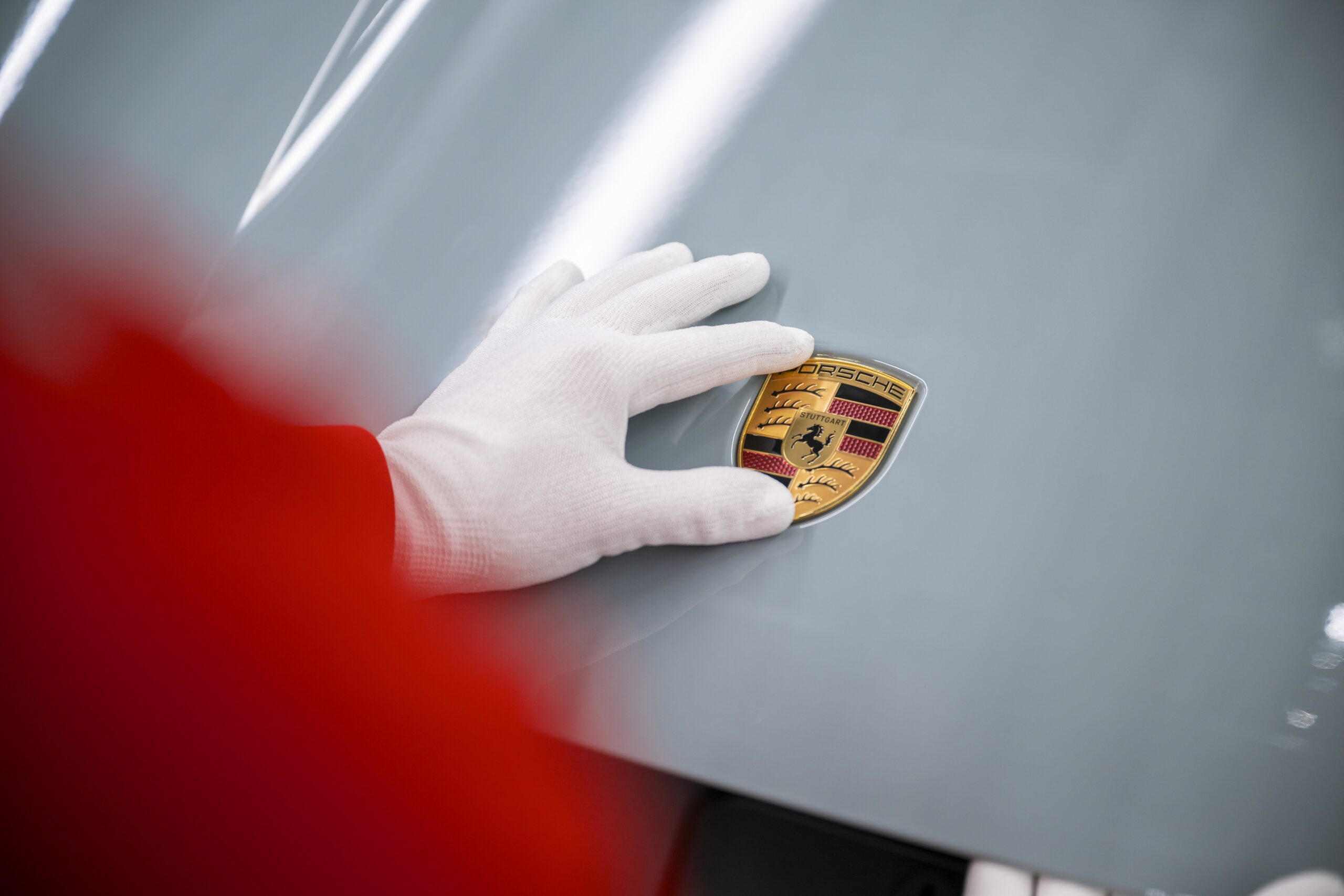Il marchio Porsche applicato sul cofano di una Taycan elettrica
