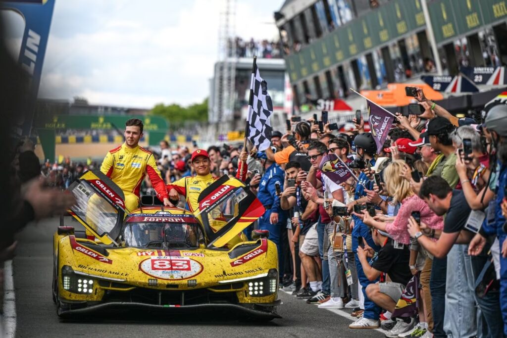 Phil Hanson, Yifei Ye e Robert Kubica in pit lane dopo aver vinto la 24 Ore di Le Mans 2025 (© Ferrari)