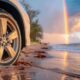 Auto su una spiaggia con l'arcobaleno
